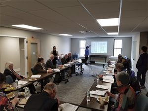 Conference room full of people looking at a presentation