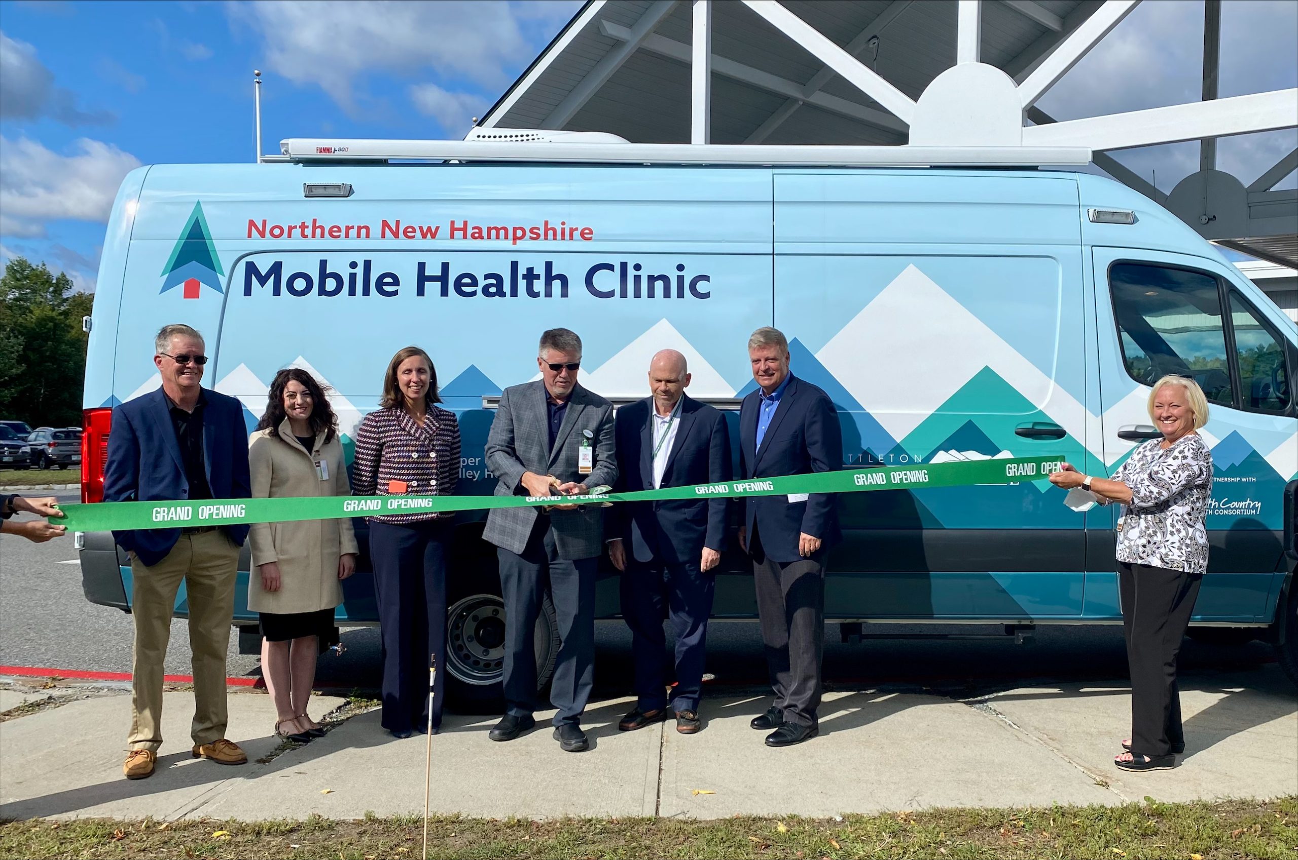 Ribbon cutting in front of van