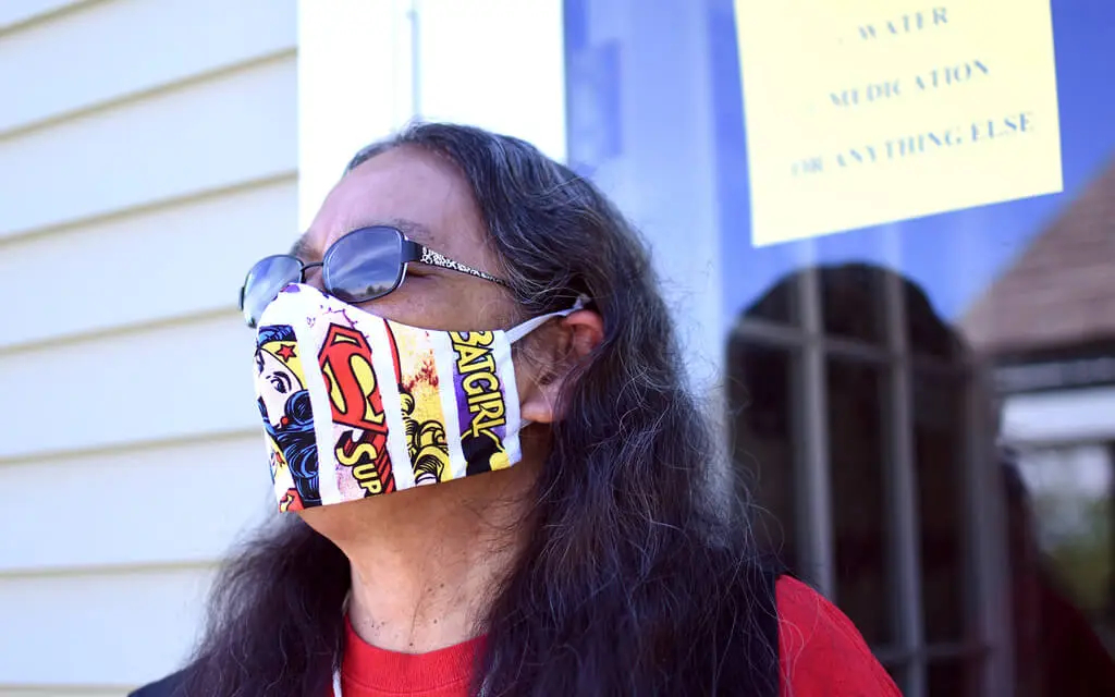 Woman wearing sunglasses and facemask looking into distance