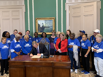 The Massachusetts Senior Action Council group celebrating signature of legislation in office